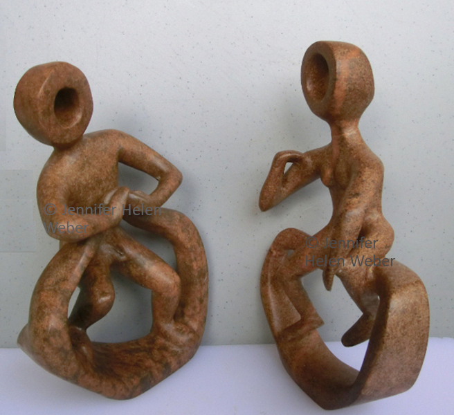 Dieses Bild zeigt zwei Specksteinskulpturen : Ein Mann, der mit einer Frau diskutiert.